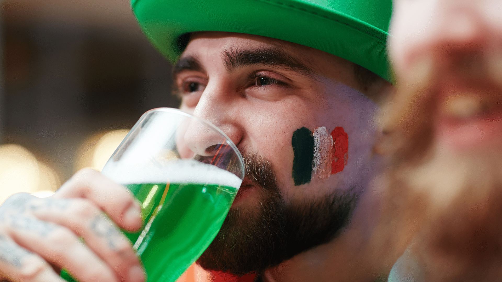 man drinking green beer at a block party on St. Patrick's Day