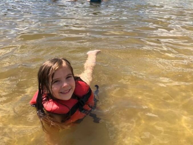 young child swimming at White Sands Day Lake Beach in Covington, Louisiana